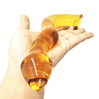 Pictured here is an image of the yellow curved glass dildo, suitable for temperature play by heating or cooling.