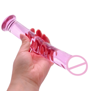 In the photograph, you can see an image of Ribbed Masturbation Stimulator Pink Dildo, a 1.06-inch wide glass wand that can be chilled or warmed for sensory play.