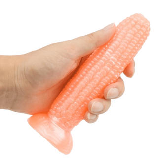 Image of a silicone dildo shaped like corn with suction cup base for hands-free play.