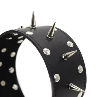 This is an image of a black leather collar with intimidating spiked nails and metal studs for BDSM play.