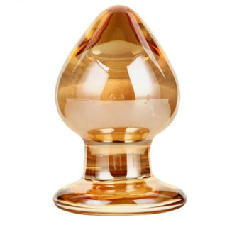 A gold-hued glass plug with a tapered head for smooth insertion.
