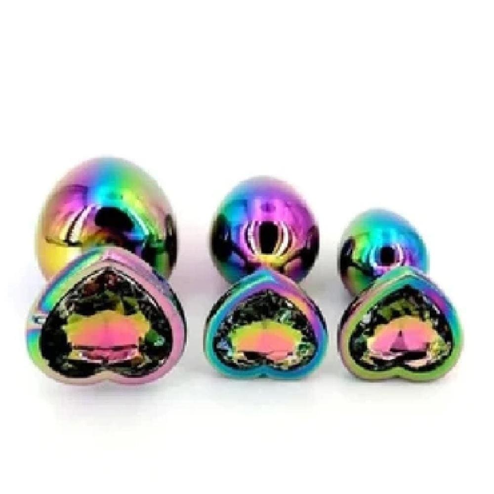 This is an image of Rainbow Princess Heart Shaped Jewel Three Steel Plug Set Men, highlighting the iridescent color and smooth texture of the metal plugs for a sensory experience.