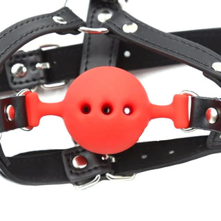 Punishment Fetish Wiffle Gag Ball in red color with body-safe silicone gag and synthetic leather straps for controlled pleasure.