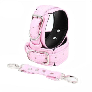 A detailed view of the D-ring connector on the Pink Leather Restraint Handcuffs