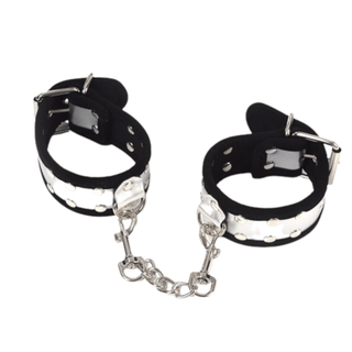 What you see is an image of Badass Metallic Leather Hand Sex Cuffs for Bondage Play in black and silver with D-rings and metal chain.