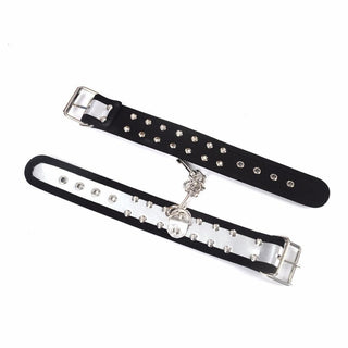 Featuring an image of fully adjustable metallic studs embedded in synthetic leather cuffs for bondage play.