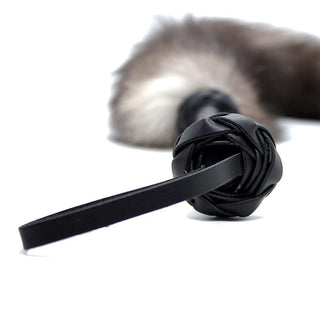This is an image of Black Handle Flogger with Fluffy Fur Tail, ready to elevate your intimate play.