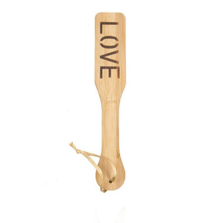 Take a look at an image of Spanking S&M Games Wooden Paddle with heart-shaped imprints for thrilling games.